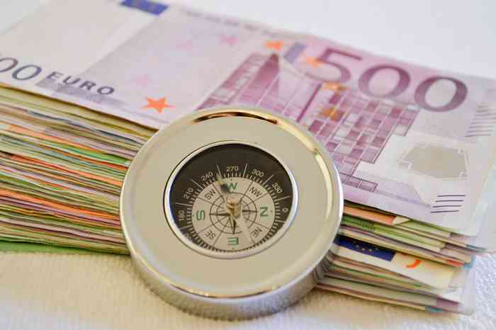 Geldscheine mit eine Kompass davor - © Martina Wendt - stock.adobe.com